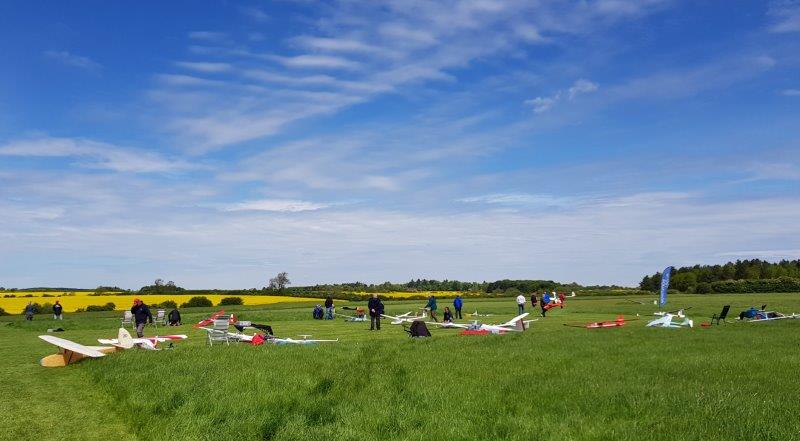 Models and members on the grass beside the runway at Langar